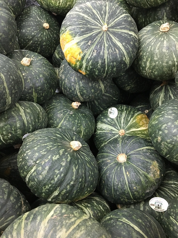 Large, green kabocha squash piled at a market