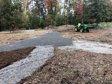 A tractor laying gravel out along paths