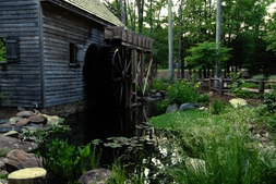 the front of the water garden featuring a pond and water wheel
