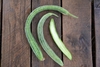 3 ribbed & curved cucumbers; one sliced to show interior.