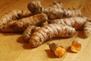 Rhizomes on a table; one is cut to show orange interior.