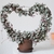 Potted vining plant trained on a heart-shaped trellis.