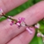 Hand cradling spikes of pink flowers.