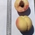 Two peaches: one whole & one-half fruit sitting on a clipboard.