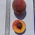 Two peaches: one whole & one-half fruit sitting on a clipboard.