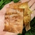Hand holding papery strips of coppery bark with lenticels.